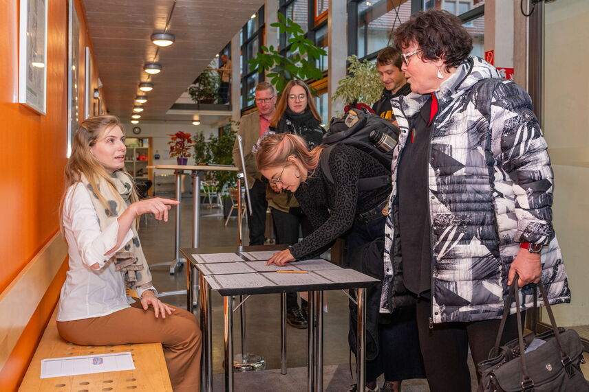 Menschen, die sich zur Anmeldung in eine Liste eintragen.