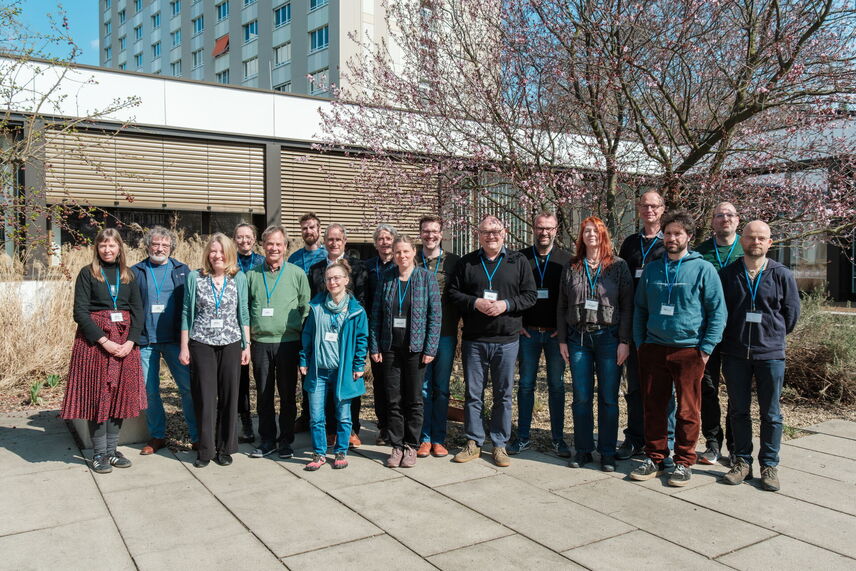 Menschen, die ein Gruppenfoto machen in einem Innenhof.