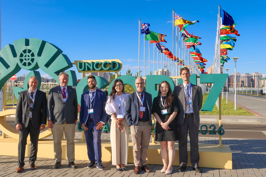 Menschen, die vor einem Schild "UNCCD COP17, Ulaanbaatar 2026" stehen.