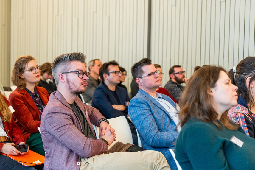 Sitzende Menschen, die in die selbe Richtung blicken.