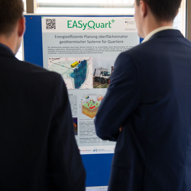 EasyQuart-Plus Zwei Personen betrachten ein EasyQuart-Plakat.