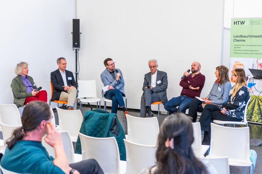 Menschen die in einem halbkreis sitzen und miteinander diskutieren