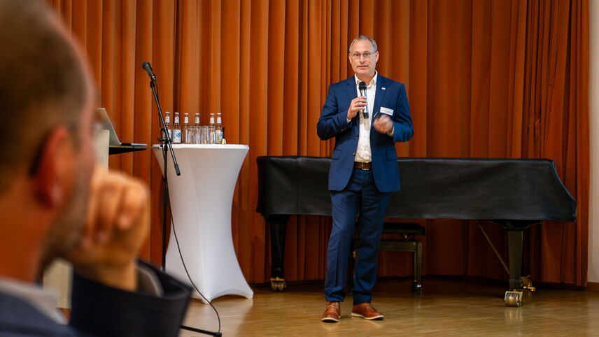 Ein Mann, der auf einer Bühne steht und spricht.