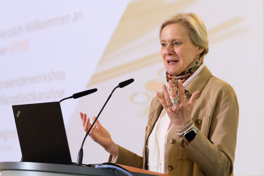 Prof. Dr. Katrin Salchert spricht am Podium mit Präsentation im Hintergrund