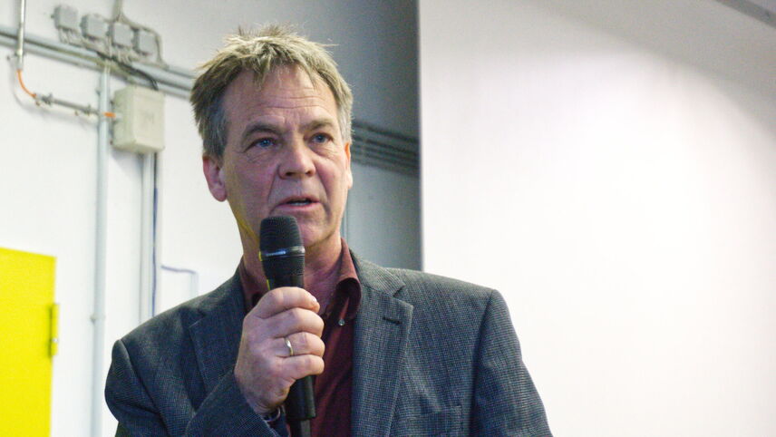 Ein Mann mit einem Mikrofon, der einen Vortrag hält.