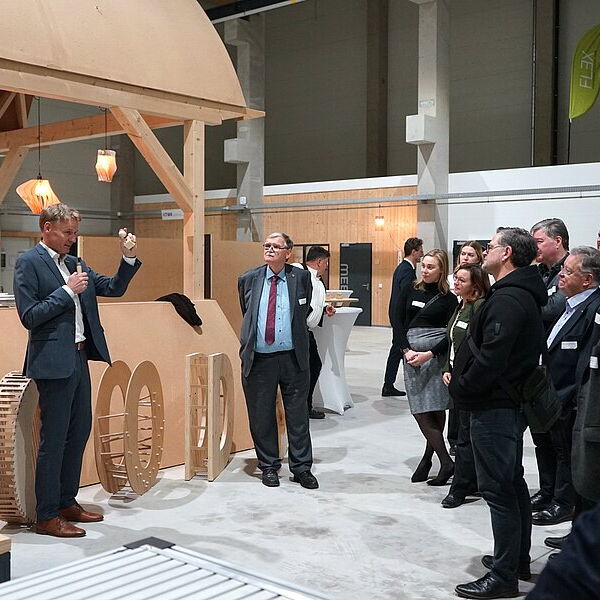 Professor demonstriert Gästen etwas zum Holzbau