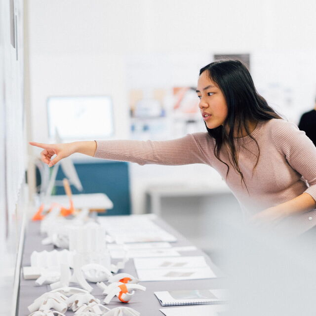 Person mit langen Haaren zeigt auf etwas