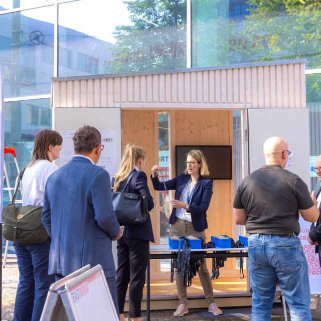 mehrere Personen holen sich ein Bändchen der Konferenz