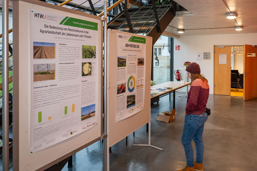 Eine Frau, die sich ein Poster zu einem Forschungsprojekt der HTWD durchliest.