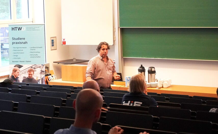 Blick auf Stephan Krüger vom HZDR, der in einem Hörsaal einen Vortrag hält, im Vordergund interessierte Zuhörende