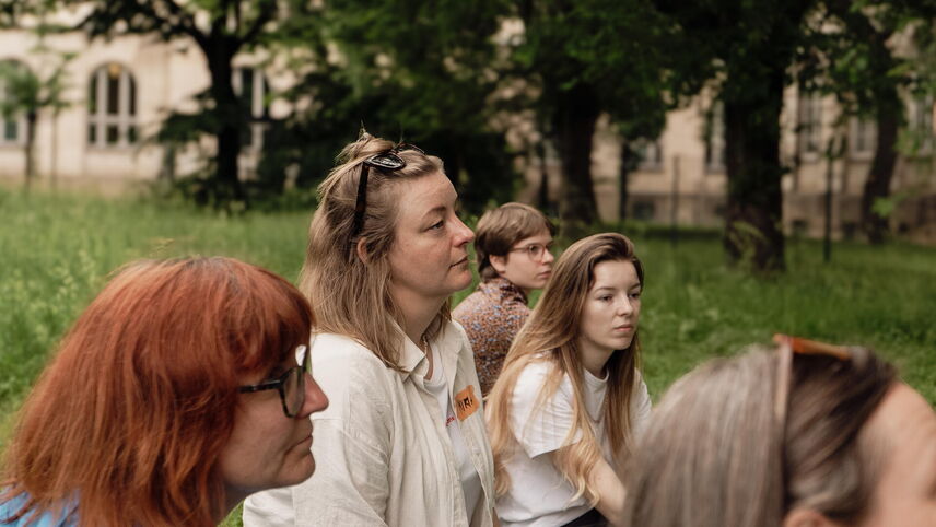 Eine Gruppe, von Frauen die auf dem Boden sitzen.
