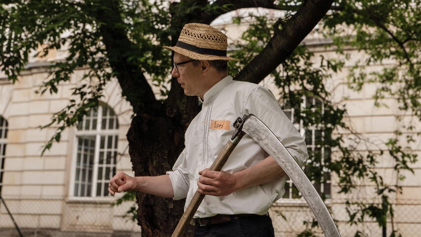 Ein Mann mit einer Sense in der Hand.