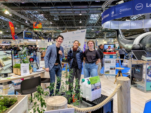 Oliver Kretschmar, Sabrina Selinger und Wiebke Zielosko stehen am Love Your Ocean-Stand