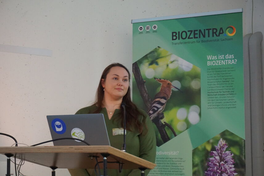 Eine Frau, die an einem Redepult steht und einen Vortrag hält.