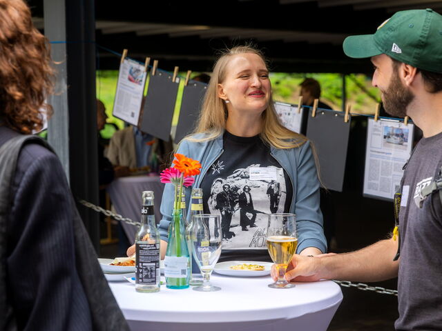 Drei Personen an einem Stehtisch