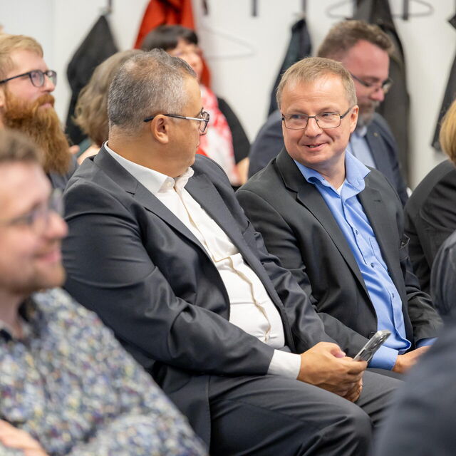 Das Publikum hört zu und nutzt die Zeit zum Netzwerken.