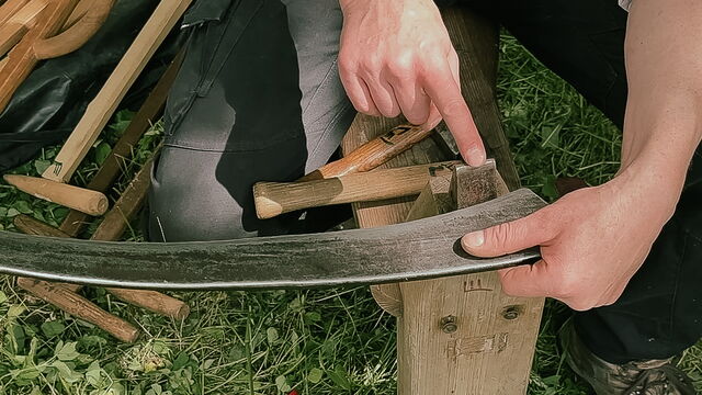 Ein Finger zeigt auf ein Teil des Dengelbocks