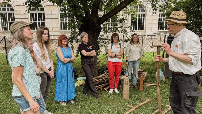 Ein Mann, der eine Gruppe von Frauen steht und redet.