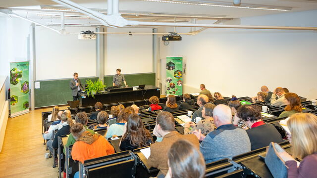 Zwei Männer, die das Publikum begrüßen.