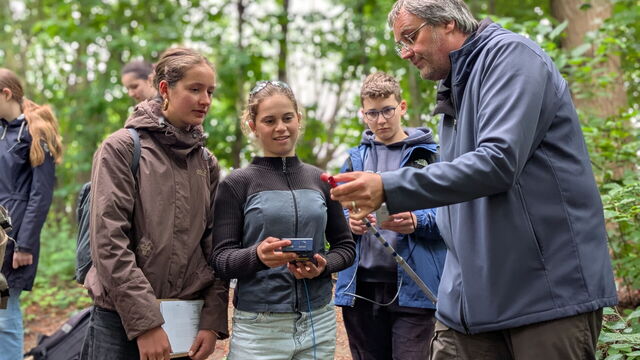 Prof. Henning Günther zeigt den Schüler*innen etwas