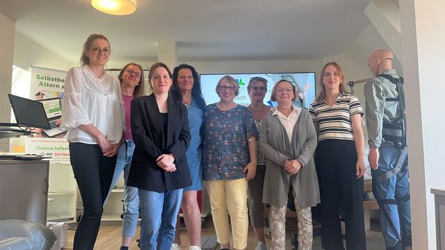 Laborleiterin Maria Fabisch, Pflegekoordinatorin Jana Horcicova und weitere Leiterinnen von Selbsthilfegruppen Pflegender Angehöriger stehen im AAL-Labor