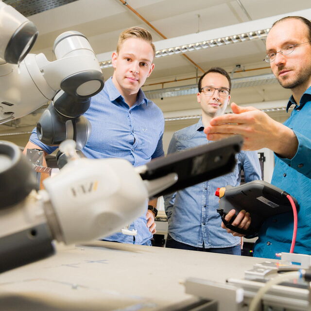 Männliche Personen erklärt zwei weiteren einen Roboter