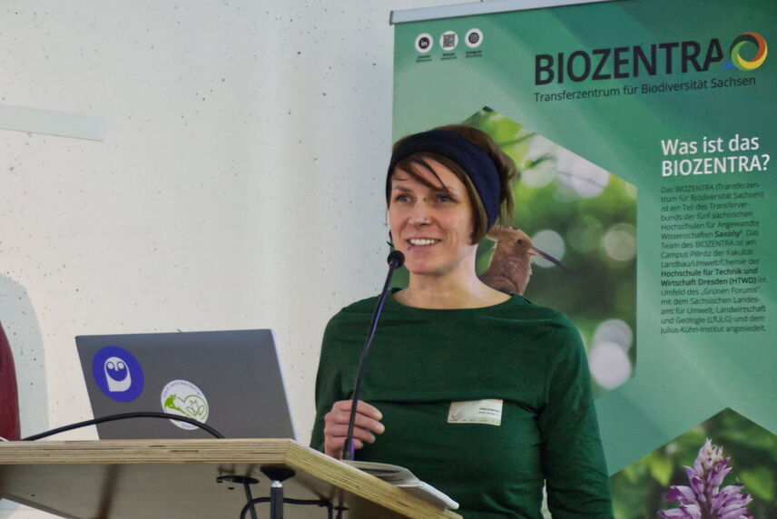 Eine Frau, die an einem Redepult steht und einen Vortrag hält.