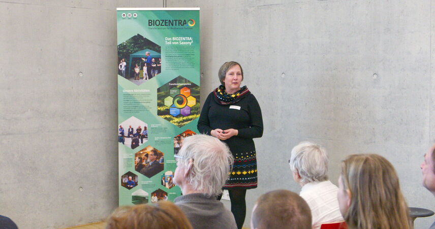 Eine Frau, die einen Vortrag vor einem Publikum hält.