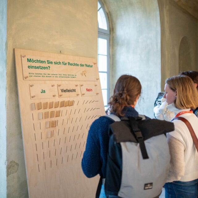 Mehrere Personen stehen vor der Abstimmungswand.