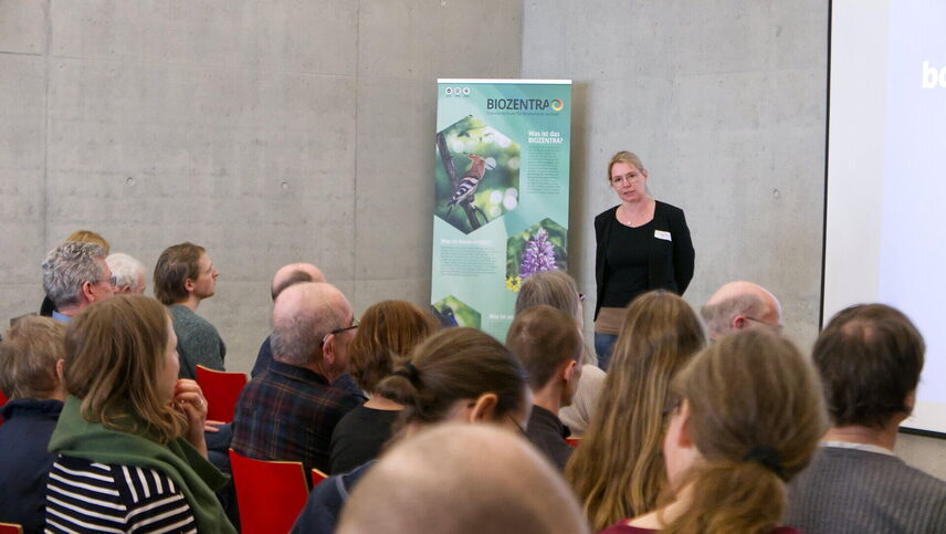 Ein Frau, die einen Redner anmoderiert.