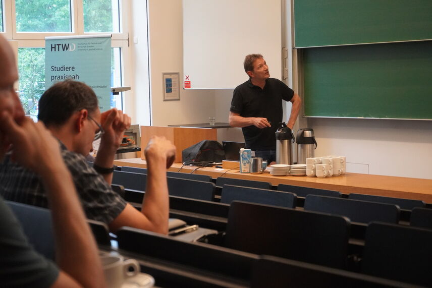 Blick auf Dr. Wolfram Palitzsch vom HZDR, der in einem Hörsaal einen Vortrag hält, im Vordergrund interessierte Zuhörende.