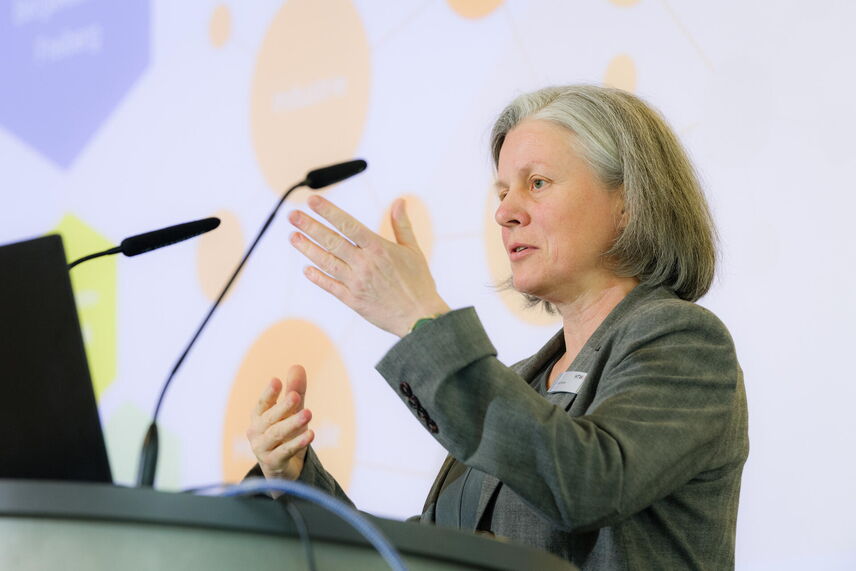 Prof. Dr. Harre spricht am Podium mit Präsentation im Hintergrund