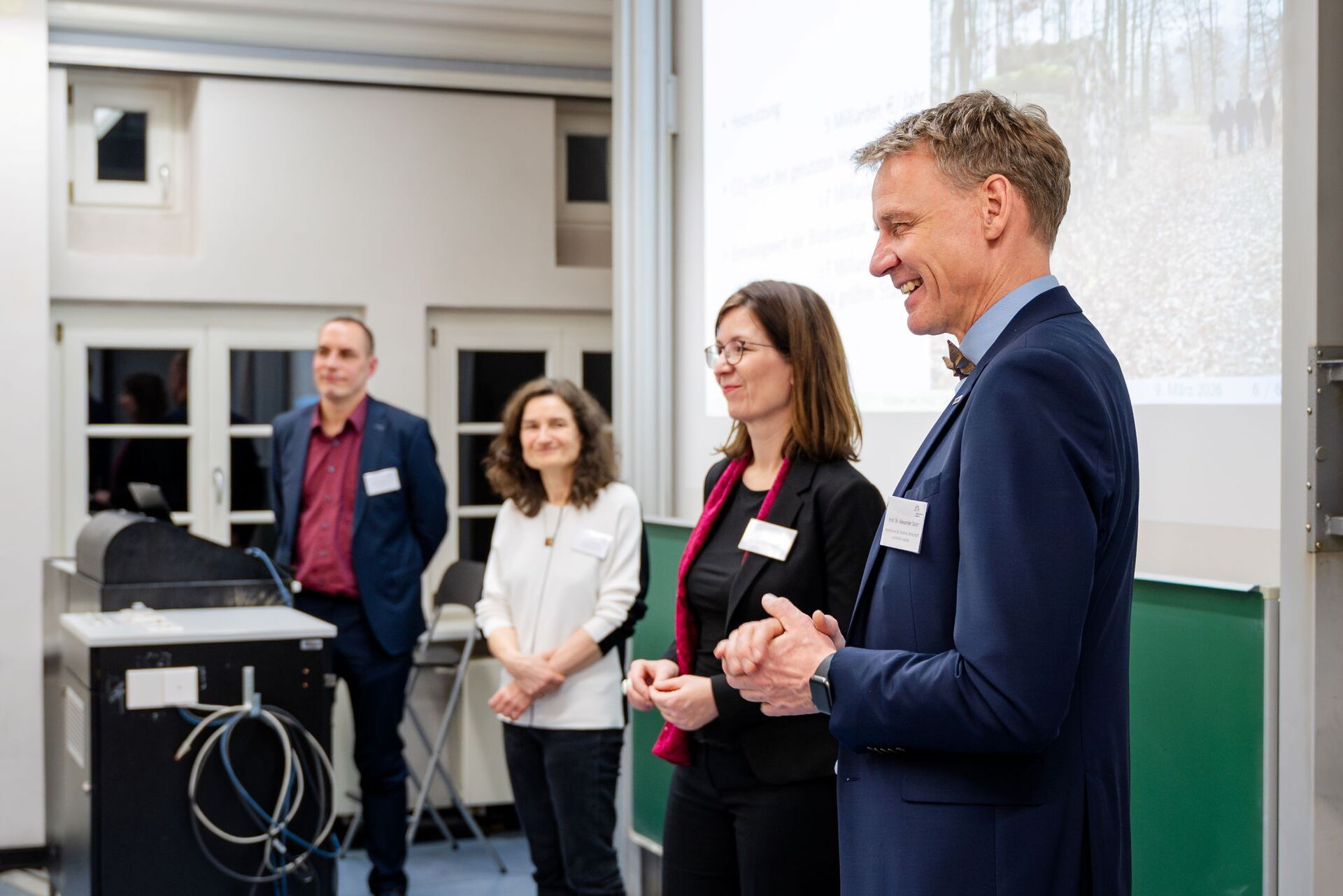 Zwei Männer und zwei Frauen stehen nebeneinander