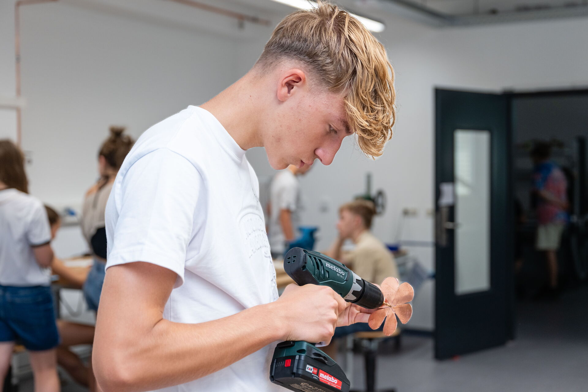 Ein Schüler mit einem Akkuschrauber