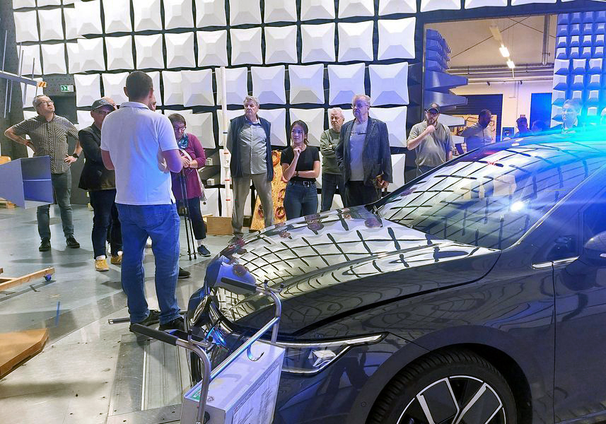 Mehrere Personen stehen in der EMV-Absorberhalle der WHZ vor einem Auto