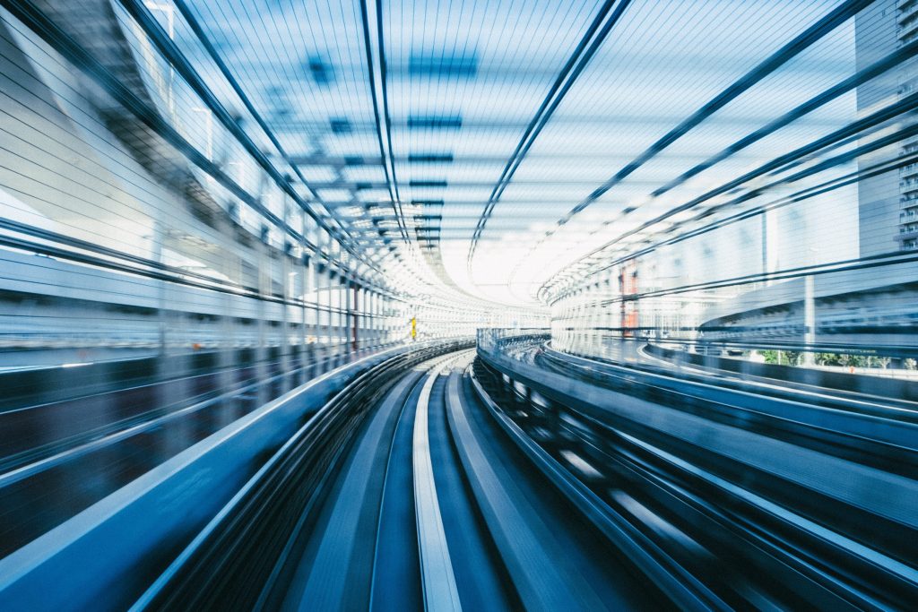 Unscharfe Bahngleise in einem Gläsernen Tunnel in Blau Weiß